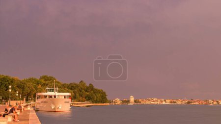 Photo for Waterfront in Venice timelapse with ship at the riva degli schiavoni and Riva dei Sette Martiri near san marco square in italian city. Stormy sky with lightnings during sunset - Royalty Free Image