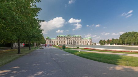 Foto de Belvedere palacio con hermoso jardín floral timelapse hiperlapso, Viena Austria. Cielo azul con nubes en un día soleado. Césped verde y edificios históricos - Imagen libre de derechos