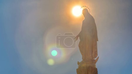 Téléchargez les photos : Holy Mary monument with sun behind it on square in front of the Cathedral timelapse in Zagreb, Croatia. Close up view. Blue sky at sunny day. - en image libre de droit