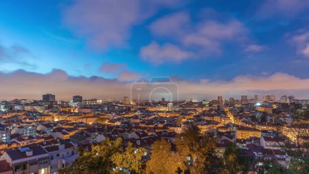 Panorama montrant la vue aérienne du centre-ville de Lisbonne de jour à nuit timelapse de transition, Portugal. Toits rouges de maisons typiques dans la vieille ville skyline. Quartier historique après le coucher du soleil dans la capitale