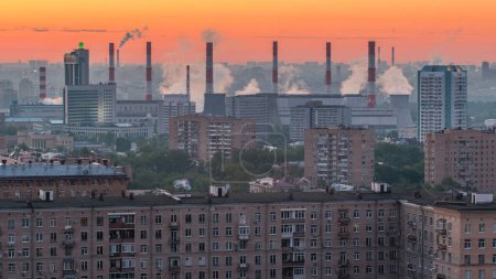 Aerial view from rooftop on Leninskiy avenue. View from top of cityscape timelapse, residential buildings, park areas, smoking pipes in distance, horizon, morning mist before sunrise, Moscow, Russia.