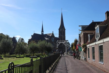 Foto de El Korendragersweg en Ouderkerk aan de Amstel, Países Bajos, con vistas a la iglesia y Kerkbrug - Imagen libre de derechos