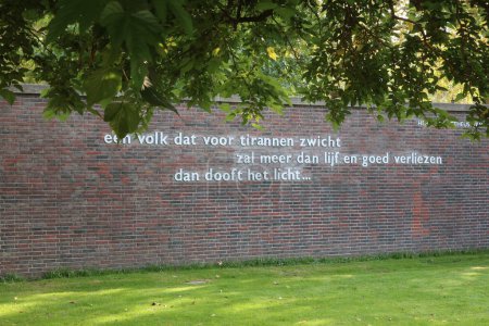 Foto de Línea final de un poema del periodista, editor y miembro de la resistencia Henk van Randwijk en la pared del parque en Amsterdam nombrado en su honor. - Imagen libre de derechos