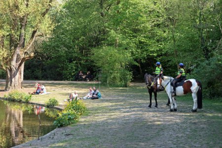 Téléchargez les photos : Deux policiers à cheval surveillent le Sarphatipark d'Amsterdam, aux Pays-Bas - en image libre de droit