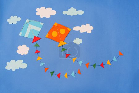 Foto de Papel artesanal colorido papel cometas y nubes sobre fondo azul - Imagen libre de derechos