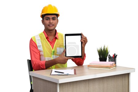 Téléchargez les photos : Architecte indien montrant écran tablette vierge tout en travaillant dans le bureau. - en image libre de droit