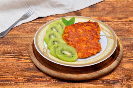 Téléchargez les photos : Sweet potato pancakes and kiwi slices on a plate - en image libre de droit