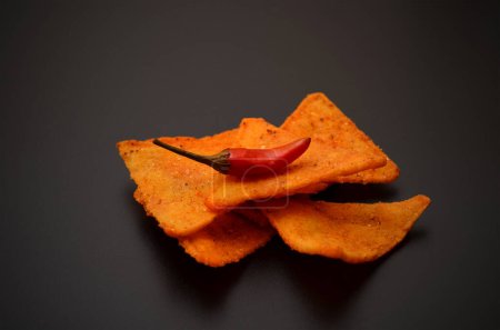 spicy mexican chips and chili peppers on a black background