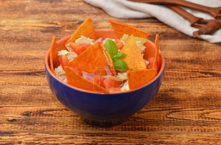 latino appetizer of vegetables, sauce and chips on a wooden background