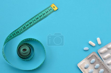 Téléchargez les photos : Measuring tape and diet pills close up - en image libre de droit