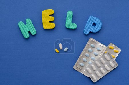 Photo for Word help and pills on blue background - Royalty Free Image