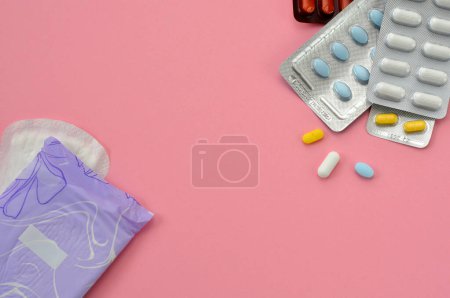 Foto de Pads and pills on a pink background, flat lay - Imagen libre de derechos