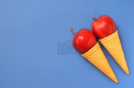 Foto de Coloridos alimentos fondo manzanas en conos de gofre, espacio para copiar - Imagen libre de derechos