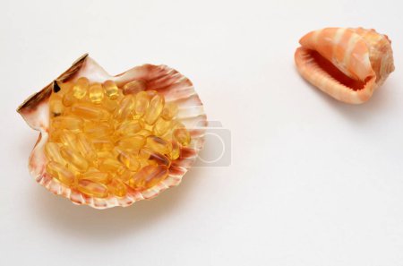 Photo for Fish oil capsules and shells symbolize the benefits of seafood - Royalty Free Image