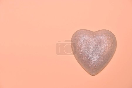 Foto de Corazón ligero sobre un fondo de melocotón, espacio para copiar - Imagen libre de derechos