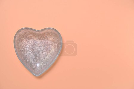 Foto de Tazón en forma de corazón sobre un fondo de melocotón, espacio para copiar - Imagen libre de derechos