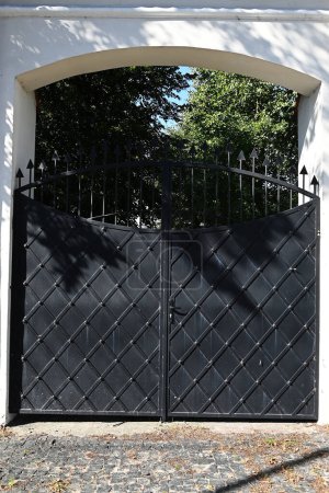black forged gates closing the entrance to private property