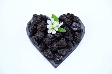 heart-shaped prunes and plum blossom on a white background