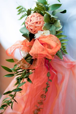 Photo for Decor made of ribbons and organza fabric, a decorative ball woven from wicker in the color Apricot Crush - the color of 2024 according to Pantone, close-up. Wedding decoration elements. - Royalty Free Image