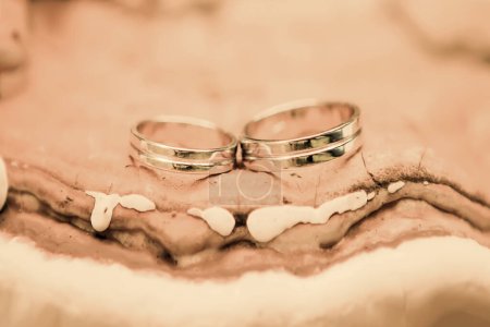 Foto de Hermosos dos anillos de boda se encuentran lujosamente en un stand natural abstracto y se destacan en el color de moda del año 2024 pelusa melocotón. Regalo para San Valentín. Pantone 2024. - Imagen libre de derechos