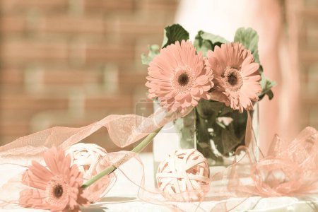 Photo for Wedding Decor of ribbons and gerbera flowers the color of the year 2024 peach fuzz, close-up.Pantone 2024. - Royalty Free Image