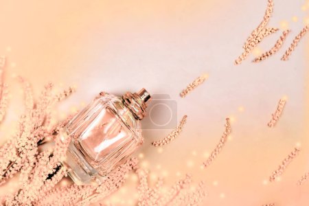festlicher Hintergrund aus verschwommenen Flecken in zarten Farbtönen des Jahres 2024 Pfirsichflaum mit Mimosenblüten und einer Flasche Parfümkosmetik. Willkommenskarte. Präsentation von Parfüms