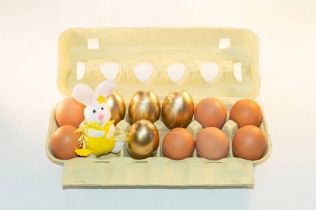 Cardboard paper tray with brown,gold eggs with a Easter bunny.Pack with dyed eggs.Price increase.Egg box,Preparation. PHOTO CREATED USING A CAMERA