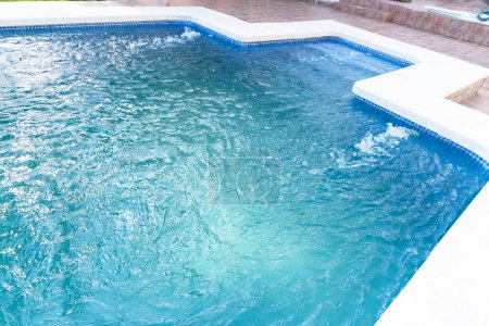Ein Strahl versprühten Wassers füllt den Pool mit sauberem Wasser und filtert es. Schwimmbadreinigung. Vorbereitung auf die Sommersaison. Smart-Home-Technologien