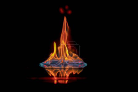 Intense flame, fire, burning brightly on a dark background, on a mirror surface with reflection,danger, catastrophic