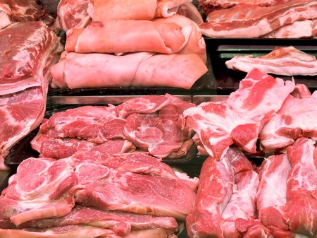 Pieces of fresh raw meat on the counter in a store, close-up. Meat background from pieces of beef and pork. Sale of meat products.