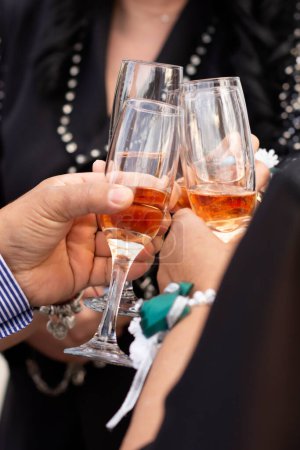 Hands with glasses filled with champagne connect them with the clink of a joyful party event at a social event.