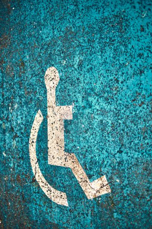 Rollstuhlfahrstreifen-Schild auf Behindertenparkplatz beschmiert.