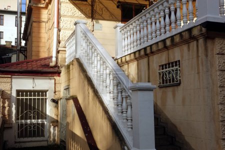 Téléchargez les photos : Escalier classique en marbre blanc de la maison du début du XXe siècle et grilles sur les fenêtres avec des nuances sur les murs - en image libre de droit