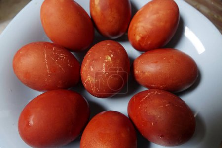 Téléchargez les photos : Assiette est remplie de nombreux œufs de Pâques rouges avec la couleur rouge-brun naturel et coquilles d'œufs texturés - en image libre de droit