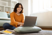 Online Education. Smiling Young Arab Woman Study With Laptop At Home, Happy Middle Eastern Female Student Typing On Computer Keyboard While Sitting On Floor In Room, Enjoying Distance Learning Poster #619145044