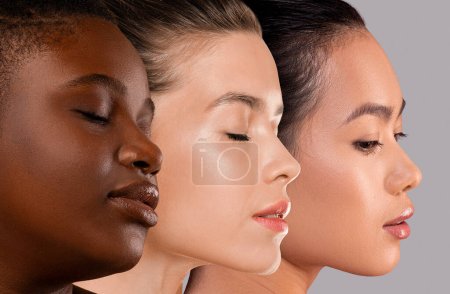 Beautiful faces of young multiracial women posing on grey studio background, attractive ladies demonstrating perfect skin, closeup, collage. Beauty, skin care, face care concept