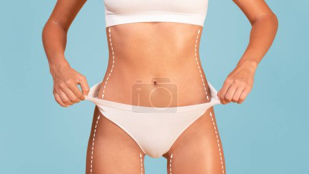 Photo for Torso Of Slim Fit Woman In White Underwear With Dashed Lines On Bosy Pulling Up Panties, Cropped Of Unrecognizable Athletic Female With Slender Figure Standing Isolated Over Blue Background, Collage - Royalty Free Image
