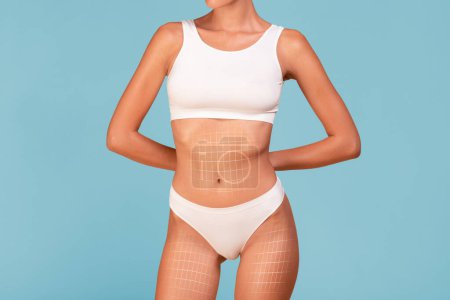 Photo for Cropped Shot Of Slim Female Torso With Drawn Lifting Up Mesh On It, Unrecognizable Young Woman With Athletic Figure In White Underwear Standing Isolated On Blue Background, Collage, Copy Space - Royalty Free Image
