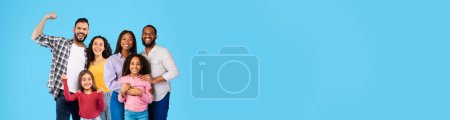 Photo for Cheerful middle eastern and black families husbands, wives and daughters posing together on blue studio background, embracing, smiling, panorama with copy space, web-banner. Family concept - Royalty Free Image