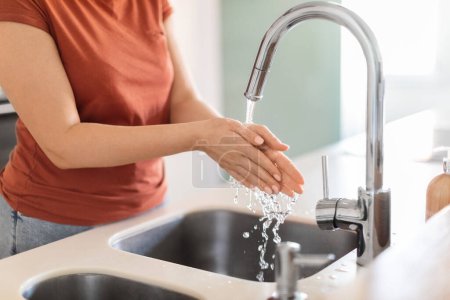 Photo for Closeup Shot Of Young Woman Washing Hands In Kitchen Sink, Unrecognizable Female Touching Running Water, Playing With Flow While Making Cleaning At Home, Lady Enjoying Domestic Chores - Royalty Free Image