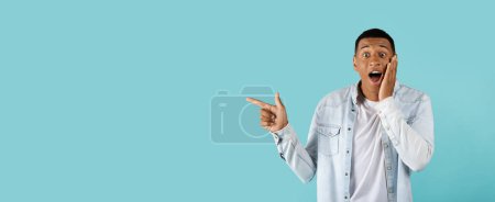 Photo for Ad and offer, huge sale. Cheerful excited young african american male in casual with open mouth showing finger up, shouting, isolated on blue background, panorama. Got idea, solution and emotions - Royalty Free Image