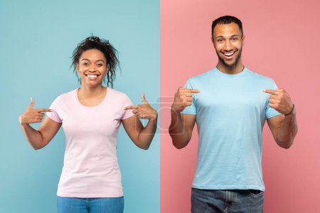 Foto de Feliz afroamericano hombre y mujer en camisetas vacías señalándose a sí mismos con los dedos y sonrientes, de color rosa y azul de fondo. Anuncio y oferta, espacio para tu diseño - Imagen libre de derechos