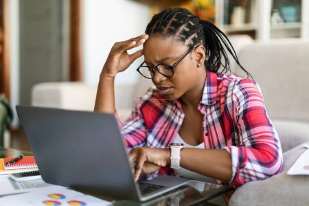Photo for Professional burnout. Depressed upset african female sit at workplace by computer touching head feel unmotivated sick lack of sleep. Desperate young black woman having problems at work missed deadline - Royalty Free Image