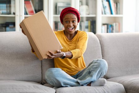 Photo for Excited emotional young black woman customer receive good parcel cardboard box at home satisfied with great purchase, happy lady consumer holding package overjoyed by postal shipping delivery - Royalty Free Image