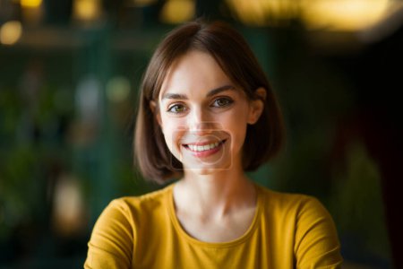 Photo for Portrait of beautiful cheerful young brunette woman with nice haircut smiling at camera while chilling or working at cafe, coffee shop, closeup, copy space. Women in business, entrepreneurship - Royalty Free Image