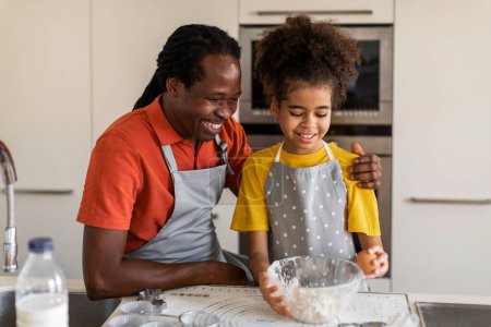 Téléchargez les photos : Caring Black Dad Teaching His Preteen Daughter How To Make Dough While Baking In Kitchen, Happy African American Family Enjoying Cooking Together, Mixing Ingredients In Bowl, Free Space - en image libre de droit