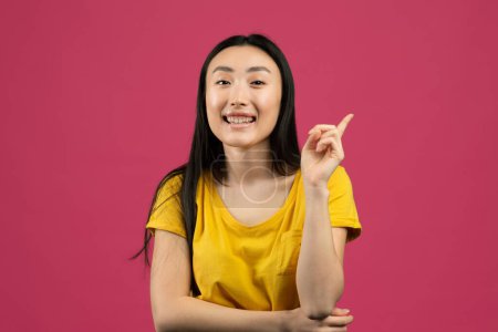 Photo for Aha moment. Portrait of happy asian lady having great idea, finding inspiration or solution to problem, posing over pink background. Cheerful chinese woman pointing finger up - Royalty Free Image
