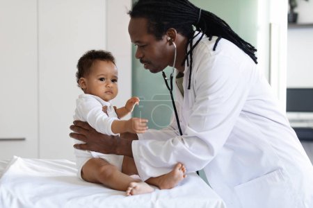 Téléchargez les photos : Baby Check Up. Black Pediatrician Doctor Examining Little Infant Boy During Appointment In Clinic, African American Medical Worker In Uniform Checking Childs Health In Hospital, Closeup - en image libre de droit