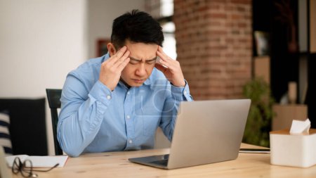 Photo for Overwork and deadline concept. Stressed middle aged asian businessman working on laptop, touching and massaging temples. Mature male having headache, reducing stress, thinking - Royalty Free Image
