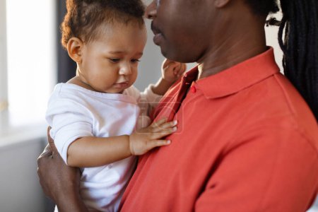 Foto de Fathers Love. Young Black Man Holding Cute Infant Son In Hands, Loving African American Dad Embracing Adorable Little Baby Boy While They Spending Time Together At Home, Closeup Shot - Imagen libre de derechos